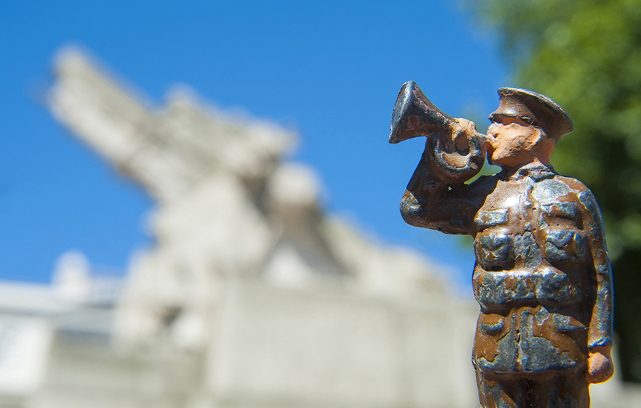 Lead toy soldier playing bugle with the Artillery Memorial, London, in the background