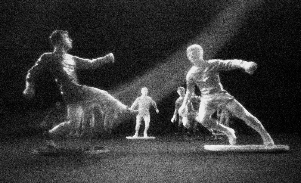 Pinhole photo of toy football players by Beowulf Mayfield