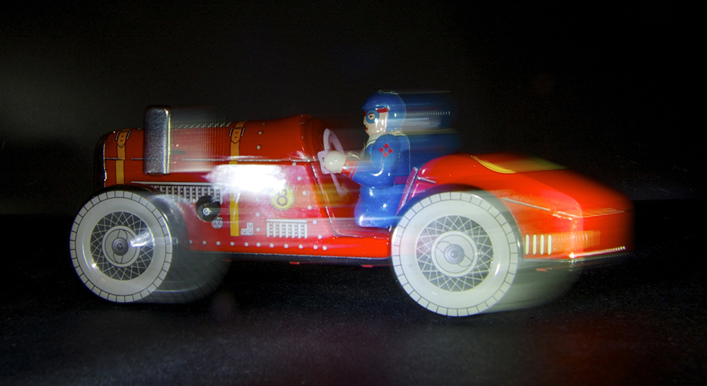 Toy red racing car in motion